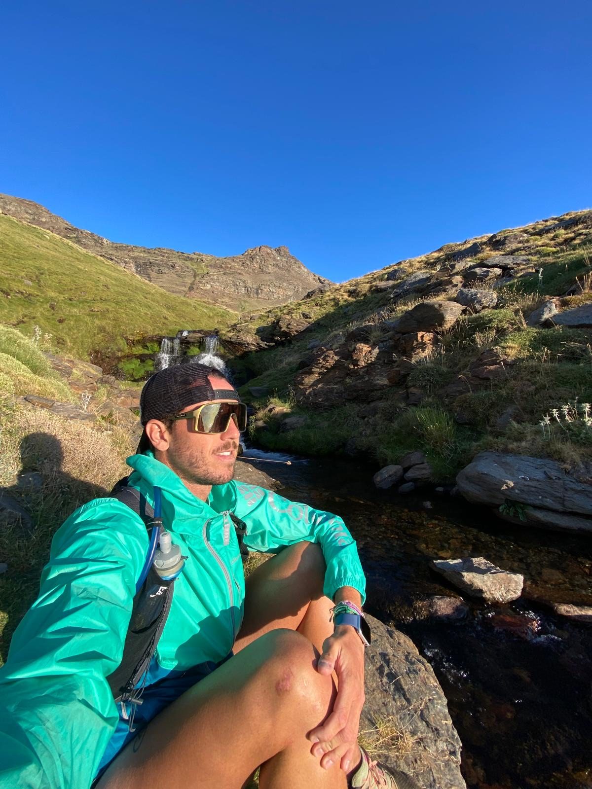Miguel descansando junto a un arroyo en la montaña