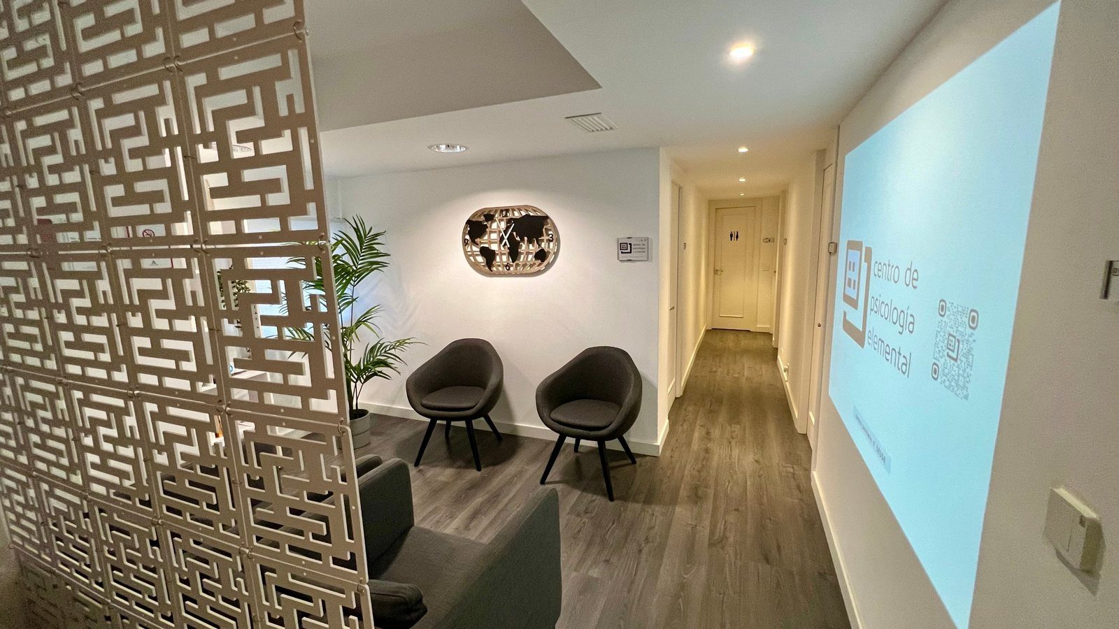 Recepción y sala de espera de Centro Elemental, con el logotipo proyectado en la pared